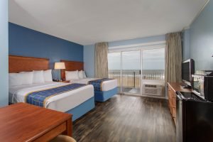hotel room with two queen beds hardwood floor and balcony with oceanfront view