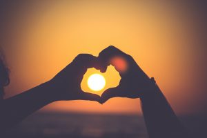 Sunset inside heart shaped hands