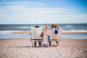 Couple sitting on beach chairs facing the ocean