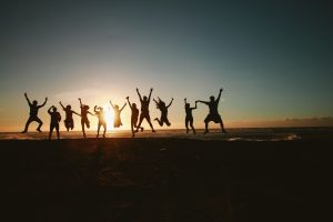 group of friends jumping on the beach.